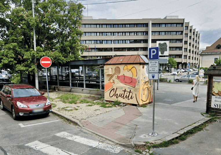 Pohľad na zastávku mestskej hromadnej dopravy Zochova. V centre je vidno starý opustený stánok.